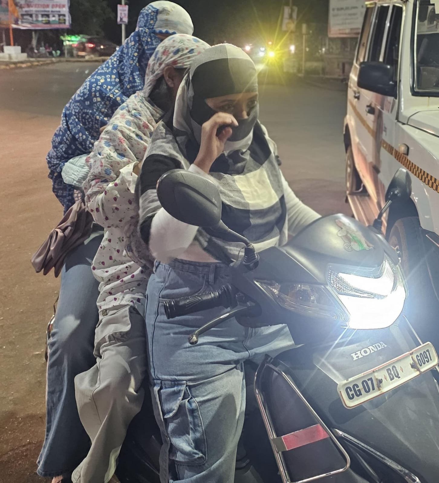 दुपहिया वाहन में तीन सवारी, बिना हेलमेट, यातायात नियमों का खुला उल्लंघन करती महिलाएं